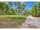 Long shot of the home with mature trees and landscaping on a sprawling, well-manicured lawn at 1240 Fox Creek Dr, Sarasota, FL 34240