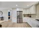 Well-lit kitchen with stainless refrigerator, white cabinetry, and modern countertops at 1240 Fox Creek Dr, Sarasota, FL 34240