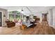 Bright living room featuring hardwood floors, a vaulted ceiling, and large windows with backyard views at 1240 Fox Creek Dr, Sarasota, FL 34240