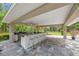 Outdoor kitchen featuring a covered patio, ceiling fan, built-in grill, and bar seating for entertaining at 1240 Fox Creek Dr, Sarasota, FL 34240
