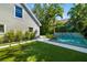 Backyard featuring artificial grass, a modern pool, and an architectural home exterior at 1434 Ladue Ln, Sarasota, FL 34231