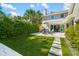 Backyard patio with a seating area, artificial turf, and mature privacy hedges at 1434 Ladue Ln, Sarasota, FL 34231