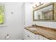 Bathroom featuring white cabinets, tan marble counters, and built-in cabinet space at 1434 Ladue Ln, Sarasota, FL 34231