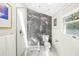 Bright bathroom with glass shower, black marble accent wall, and white tile at 1434 Ladue Ln, Sarasota, FL 34231