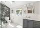 Modern bathroom featuring a glass-enclosed shower with marble tile, vanity with grey cabinets at 1434 Ladue Ln, Sarasota, FL 34231