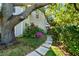 Beautifully landscaped yard with a stone pathway, vibrant flowers, and mature trees enhancing the home's appeal at 1434 Ladue Ln, Sarasota, FL 34231