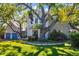 Beautiful home exterior with lush greenery, mature trees, and a spacious lawn, showcasing a serene outdoor setting at 1434 Ladue Ln, Sarasota, FL 34231