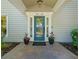 Elegant blue front door with decorative sidelights and an address plaque, enhanced by potted flowers at 1434 Ladue Ln, Sarasota, FL 34231