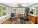 Bright home office with large windows, wood floors, ceiling fan, and built-in cabinets provides ample natural light at 1434 Ladue Ln, Sarasota, FL 34231