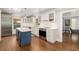 Bright kitchen with a center island, stainless steel appliances, custom cabinetry, and hardwood floors at 1434 Ladue Ln, Sarasota, FL 34231