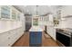 Spacious kitchen featuring an island, white cabinetry, stainless steel appliances, and hardwood floors at 1434 Ladue Ln, Sarasota, FL 34231