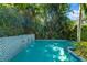 Inviting backyard pool complete with mosaic tiled waterfall and tropical plants at 1434 Ladue Ln, Sarasota, FL 34231