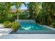 Sparkling backyard pool with fountain feature and tropical landscaping, perfect for relaxation at 1434 Ladue Ln, Sarasota, FL 34231