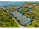 Aerial view of the community tennis courts, with a clubhouse, marina and tropical landscaping at 1434 Ladue Ln, Sarasota, FL 34231