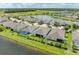 Aerial view showcases a community with lush greenery, tranquil pond, and various home styles at 15612 Trinity Fall Way, Bradenton, FL 34212