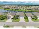 An aerial view of several houses next to a lake, showcasing their roofs, landscaping, and driveways at 15612 Trinity Fall Way, Bradenton, FL 34212