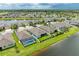 Aerial view showing community layout, canal, green spaces, and screened pools in a residential neighborhood at 15612 Trinity Fall Way, Bradenton, FL 34212