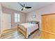 Comfortable bedroom features hardwood floors, ceiling fan, light purple walls and a closet at 15612 Trinity Fall Way, Bradenton, FL 34212