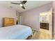 Bedroom boasts hardwood floors, ceiling fan, closet, dresser and an adjacent bathroom at 15612 Trinity Fall Way, Bradenton, FL 34212