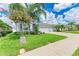 Beautiful home featuring a lush green lawn, decorative trees, and a long concrete driveway at 15612 Trinity Fall Way, Bradenton, FL 34212