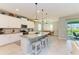 Kitchen island with granite countertops, pendant lighting, and seating for casual dining at 15612 Trinity Fall Way, Bradenton, FL 34212