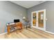 Home office features hardwood floors, a glass paned door, and a wooden desk with office chair at 15612 Trinity Fall Way, Bradenton, FL 34212