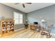 Home office with wood-look flooring, a ceiling fan, lots of sunlight and a beautiful bookcase at 15612 Trinity Fall Way, Bradenton, FL 34212