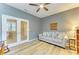 Cozy office space with french doors, ceiling fan and modern gray couch with decorative pillows at 15612 Trinity Fall Way, Bradenton, FL 34212