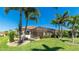 Lush backyard featuring a screened-in lanai, well-manicured lawn, and tropical palm trees at 20114 Uffizi Ct, Venice, FL 34293