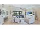 Elegant living room featuring tray ceilings, tile floors, and expansive sliding glass doors at 20114 Uffizi Ct, Venice, FL 34293