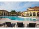 Beautiful community pool with elegant clubhouse, inviting lounge chairs and lush tropical landscaping at 20114 Uffizi Ct, Venice, FL 34293