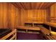 Inviting sauna room with wooden benches, a grill, and a traditional design at 20114 Uffizi Ct, Venice, FL 34293