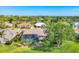Aerial shot of a home with a screened-in pool, set within a lush, tree-lined community and golf course at 2020 Calusa Lakes Blvd, Nokomis, FL 34275