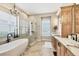 Bright bathroom featuring a soaking tub, glass shower, and custom wood cabinets with quartz countertops at 2020 Calusa Lakes Blvd, Nokomis, FL 34275