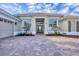 Charming home with a paver driveway, large windows, and meticulously maintained landscaping at 2020 Calusa Lakes Blvd, Nokomis, FL 34275