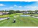 Scenic aerial view of meticulously maintained golf course with water features, golf carts, and lush green fairways at 2020 Calusa Lakes Blvd, Nokomis, FL 34275