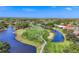 Aerial view of a beautiful golf course with water features and meticulously maintained green fairways and tee boxes at 2020 Calusa Lakes Blvd, Nokomis, FL 34275