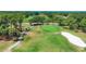 Aerial view of a golf course with golfers, sand traps, and lush green fairways and putting greens at 2020 Calusa Lakes Blvd, Nokomis, FL 34275