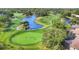 Scenic aerial view of golf course with players, water features, golf carts, and lush green fairways and putting greens at 2020 Calusa Lakes Blvd, Nokomis, FL 34275