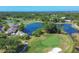 Expansive aerial view of the golf course with lush greenery, water features and community clubhouse at 2020 Calusa Lakes Blvd, Nokomis, FL 34275