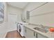 Laundry room featuring cabinets, a sink, a hanging rack, and a door leading to the outside at 2020 Calusa Lakes Blvd, Nokomis, FL 34275