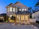 Elegant two-story home featuring a welcoming front porch with columns and a well-manicured yard at twilight at 2159 Hawthorne St, Sarasota, FL 34239