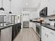 Contemporary kitchen features white cabinets, black countertops, and stainless steel appliances at 2159 Hawthorne St, Sarasota, FL 34239