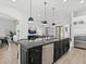 Expansive kitchen island with bar seating and a stainless steel dishwasher offers an open floor plan at 2159 Hawthorne St, Sarasota, FL 34239