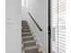 Carpeted staircase with black handrail and white trim, leading to the upper level at 2159 Hawthorne St, Sarasota, FL 34239