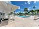 Lovely community pool surrounded by a brick patio, tables and seating at 216 Palm Air Dr, Osprey, FL 34229