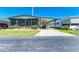 Charming home with a carport, screened porch, and vibrant landscaping on a sunny day at 216 Palm Air Dr, Osprey, FL 34229