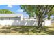 A well-maintained backyard featuring a crisp white privacy fence with a large mature tree at 218 80Th N Ave, St Petersburg, FL 33702