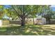 The property's backyard features a large shade tree, a wooden shed, and a newly constructed wood fence at 218 80Th N Ave, St Petersburg, FL 33702
