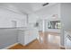 Kitchen pass through with granite countertop leading to bright and airy living room with hardwood floors at 218 80Th N Ave, St Petersburg, FL 33702